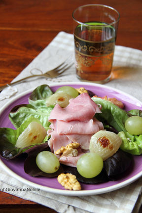 Insalata con lattughino, prosciutto cotto Lenti & Lode, cipollotti al forno, uva e noci, con vinaigrette all'aceto di lamponi