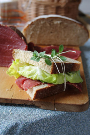 Tramezzini di pane integrale, farciti con manzo affumicato Lenti, lattuga e vinaigrette aromatica