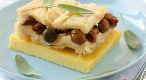 Stoccafisso con funghi e pomodori secchi su crostoni di polenta.