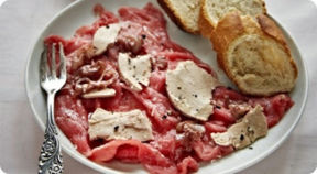 Carpaccio di manzo con foie gras e salsa calda al tartufo.