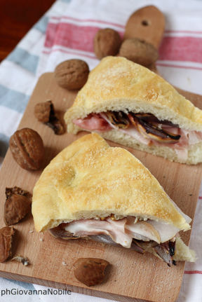 Tranci di focaccia farciti con prosciutto cotto Lenti & Lode Cuore, scalogni caramellati e noci fresche